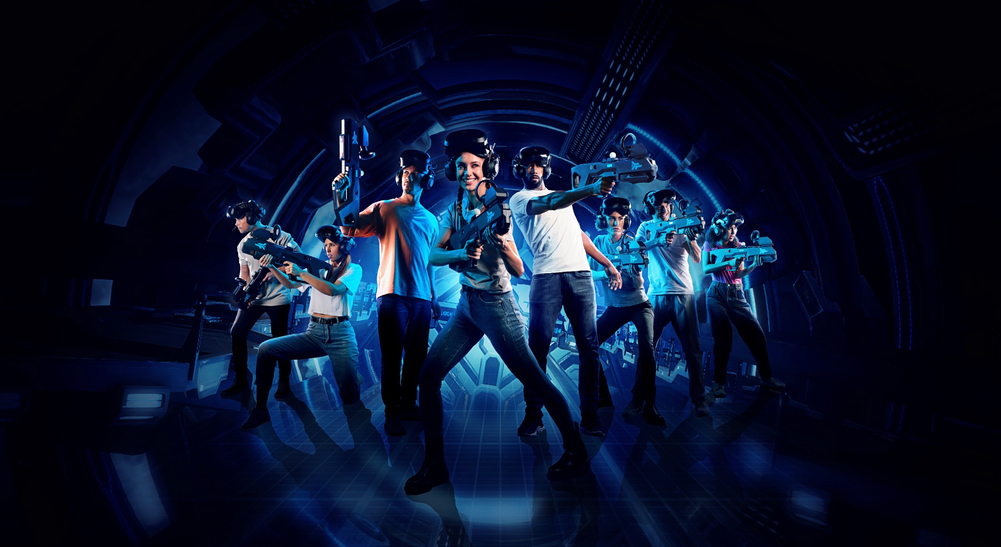 A full group of Zero Latency VR players posing with controllers in a futuristic arena